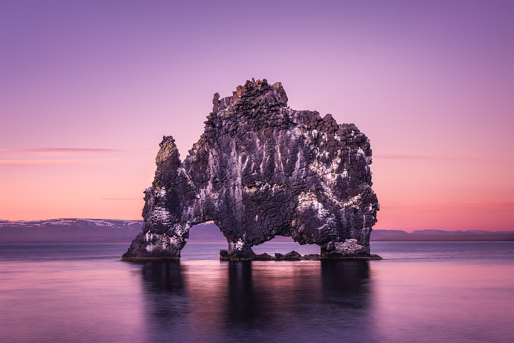 Hvitserkur at sunset off the coast of Iceland with reflection in the ocean.