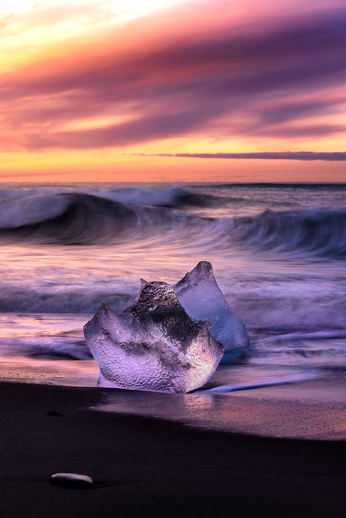 chunks of ice on black sand beach on the south coast of Iceland at sunrise.