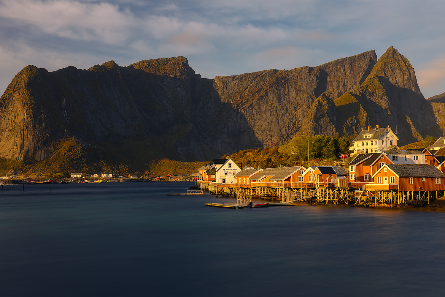 Fisherman cabins in the Lofoten Islands catch the rising suns warm glowing light