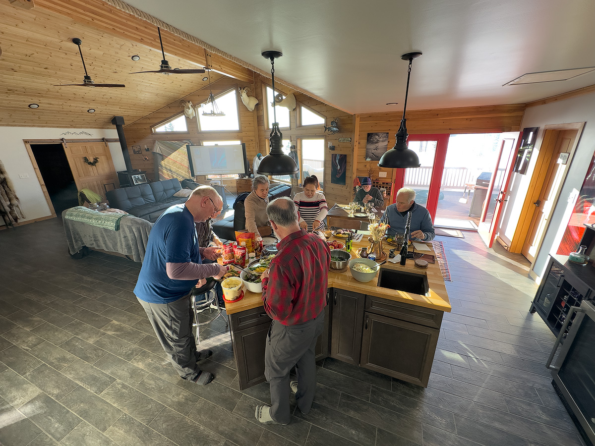 Workshop participants gathered at a home BBQ and image critique session during the Spring 2026 Northern Lights Workshop in Alaska