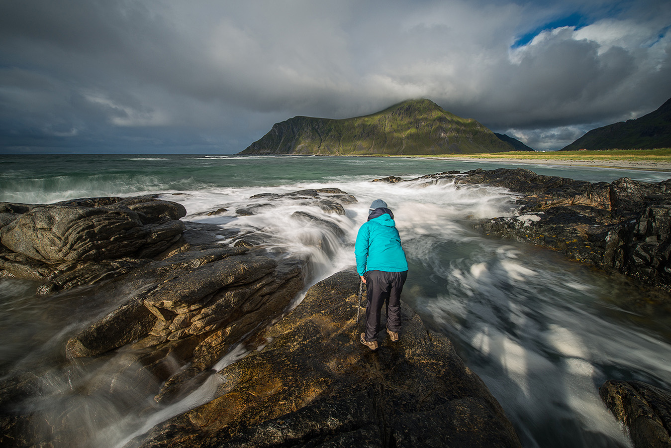 Workshop participant capturing a long exposure of breaking waves on a Lofoten Islands beach in Northern Norway