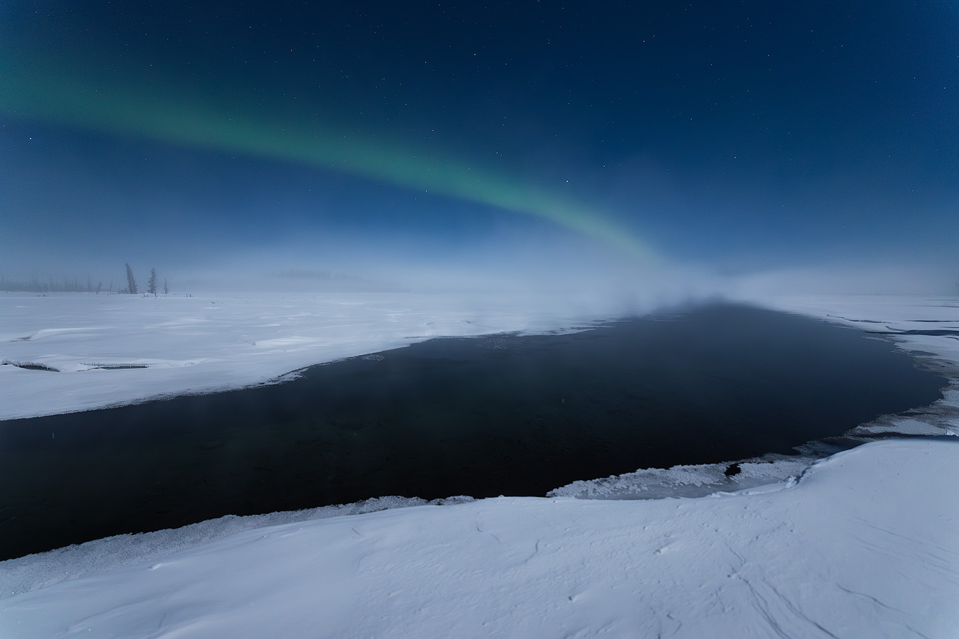 Aurora arc over an unfrozen lake with ice fog rising at -40°F during the first night of the Spring 2026 Northern Lights Workshop in Alaska