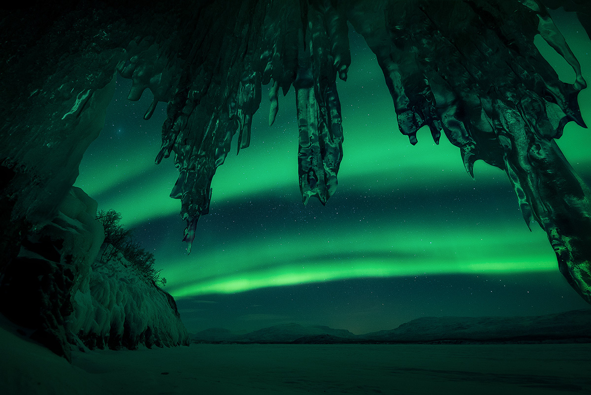 Aurora borealis framed through an ice cave in Northern Nordland, Norway