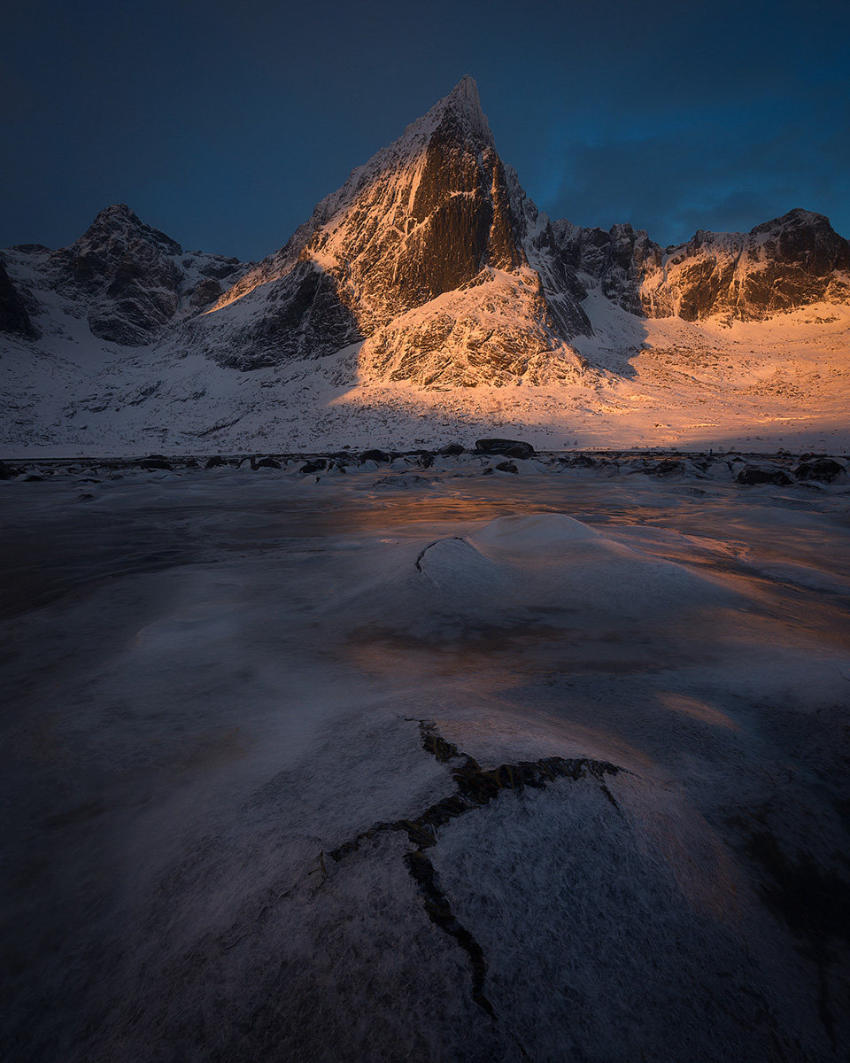 Golden hour light on a frozen fjord and granite peaks in Northern Nordland, Norway