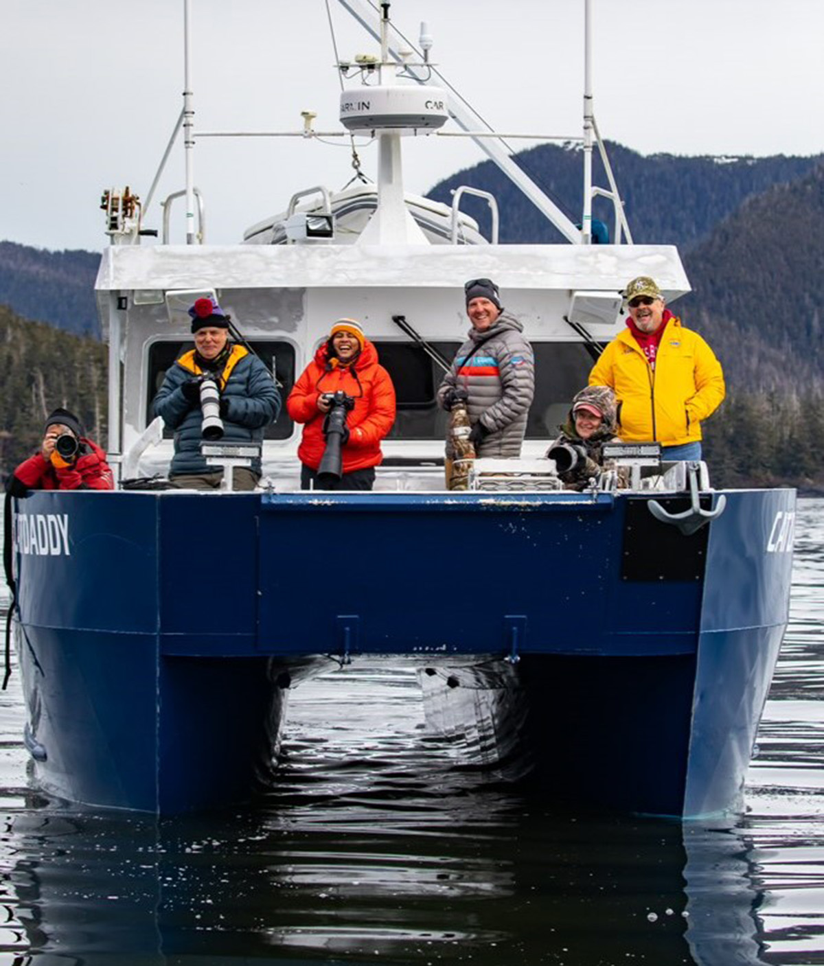 Photographers with telephoto lenses photograph bubble-net feeding humpback whales Alaska