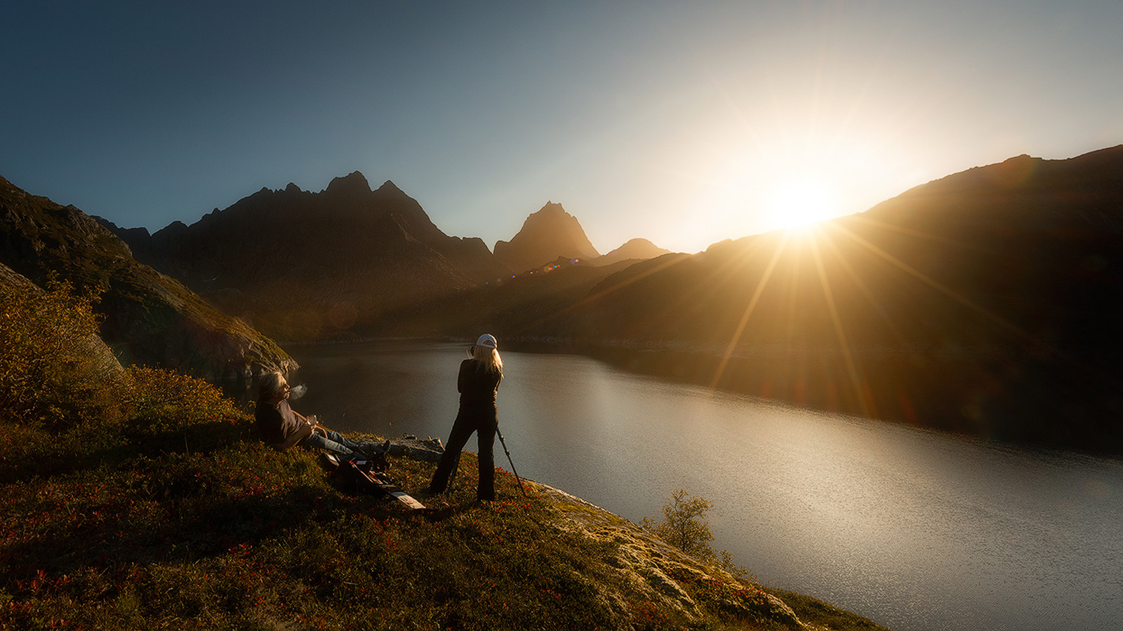 Workshop participants at sunrise photographing Solbj&oslash;rn fjord at dawn in the Lofoten Islands, Norway