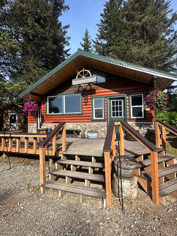 Wood-walled common area and family-style dining at Silver Salmon Creek Lodge Lake Clark &mdash; Alaska bear photography workshop image review and chef-prepared meals June